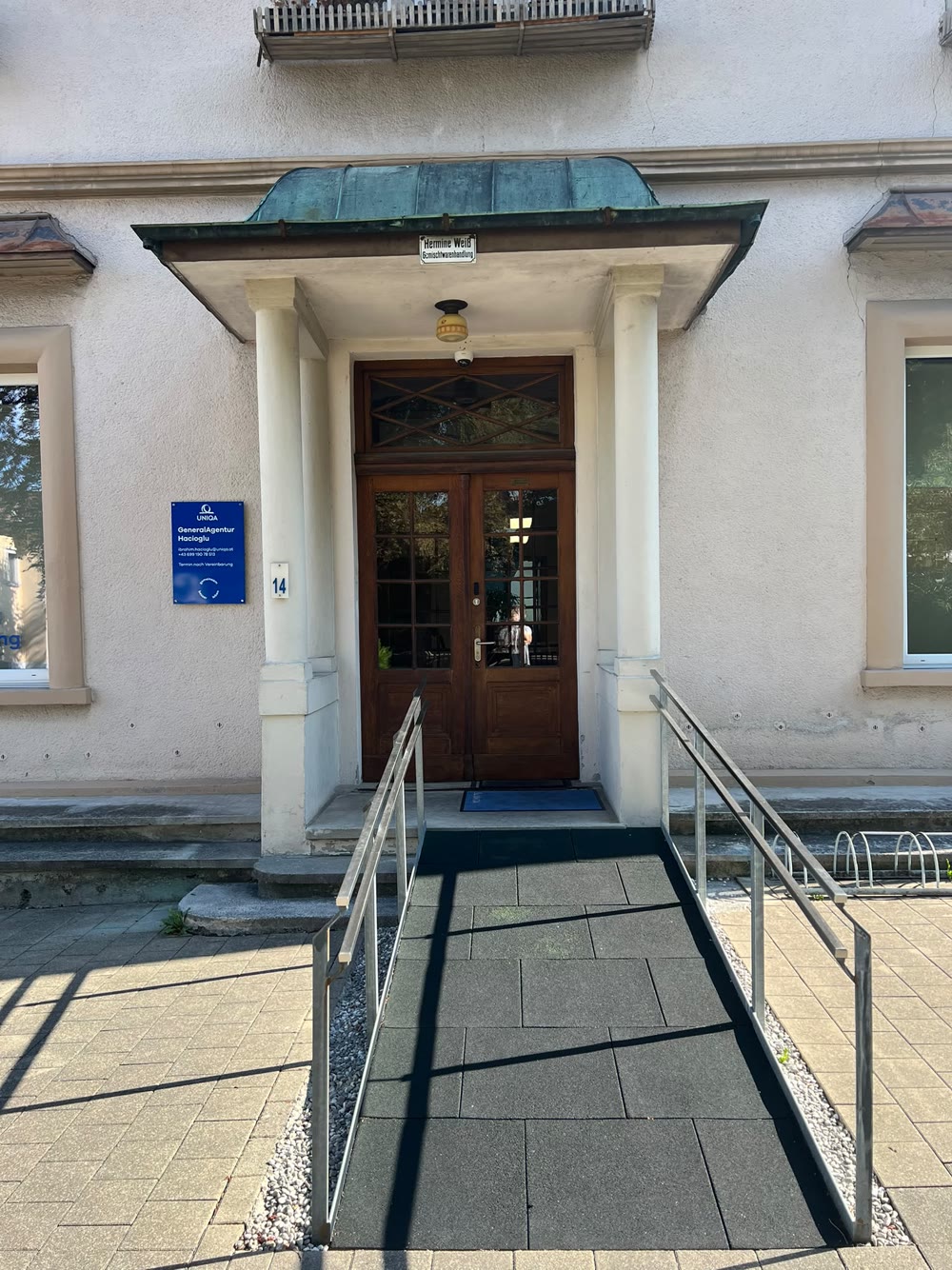 Der Haupteingang mit Kupfervordach und barrierefreier Rampe